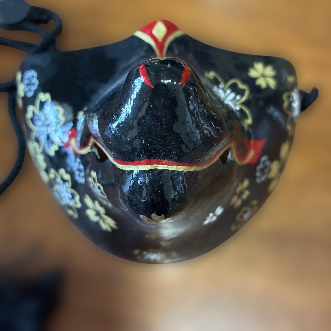 花柄装飾の黒い陶器のマスク