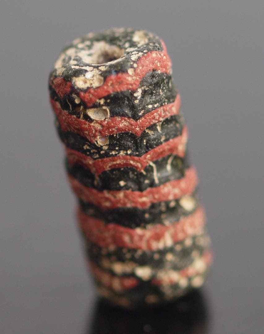 大型の漆黒管玉に、赤茶の螺旋紋と細く浅い引っ掻き紋1-4Cローマン・ビーズ銀化も