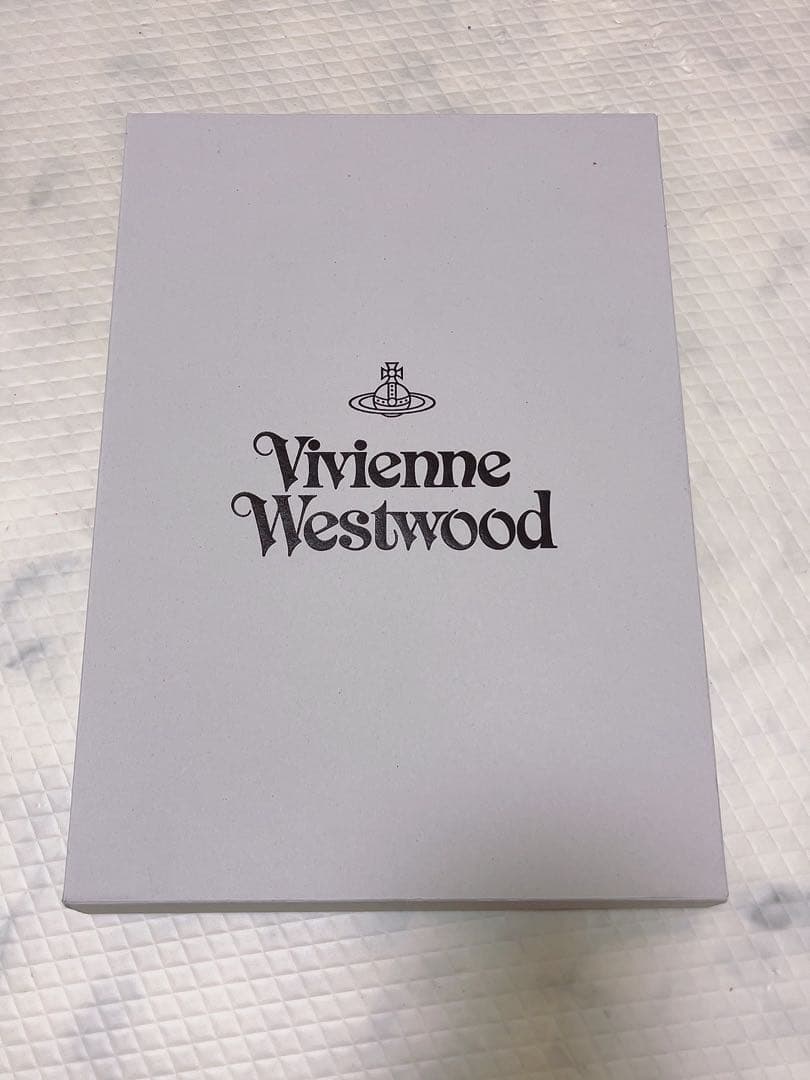 ピンクのウール製マフラー、Vivienne Westwoodのロゴ刺繍入り。